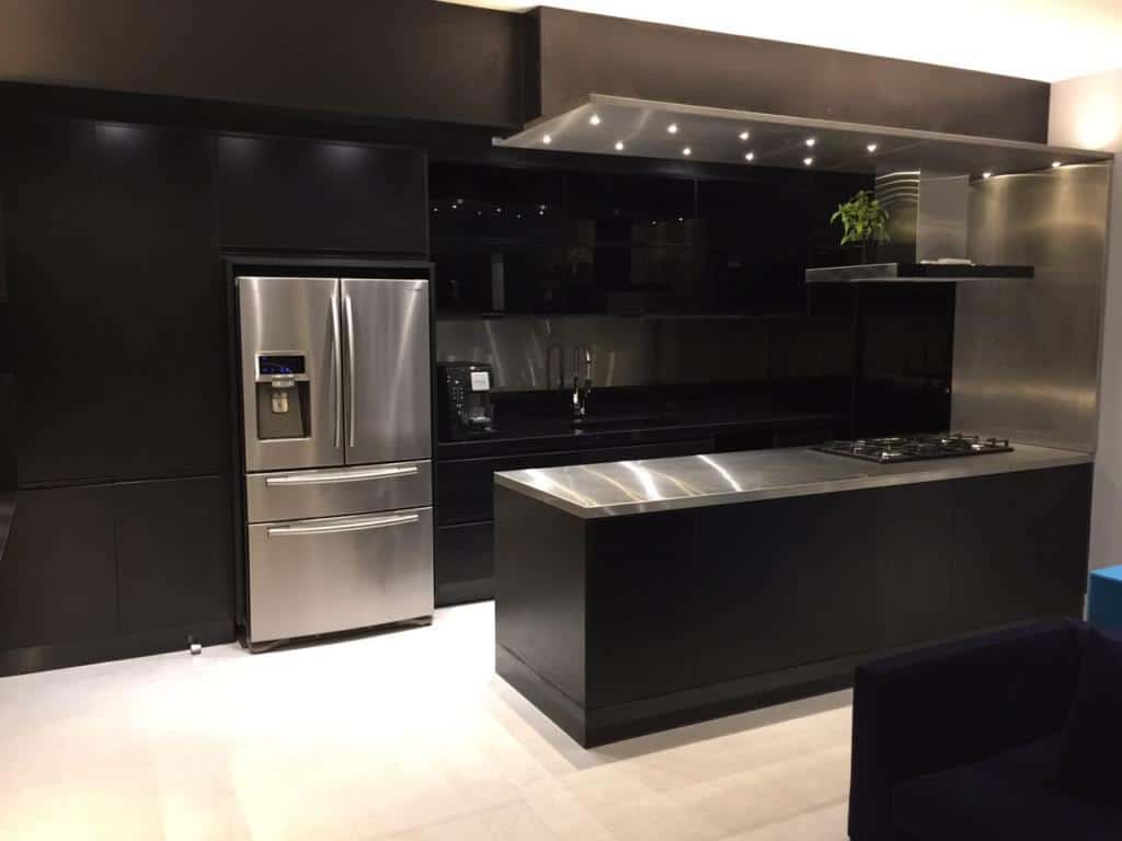 Cozinha modulada preta com bancada de madeira