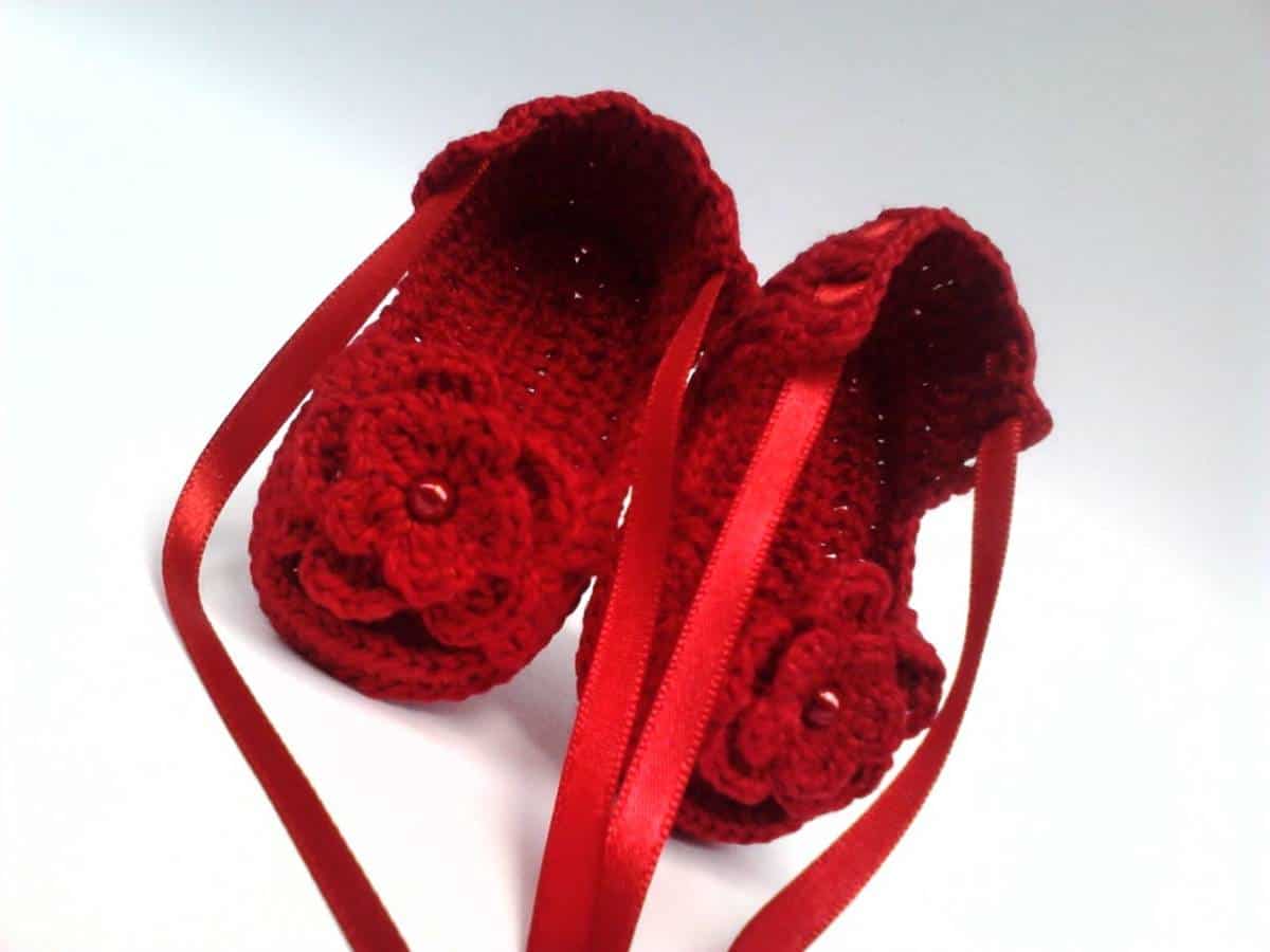 Sapatinho de crochê vermelho com florzinha.
