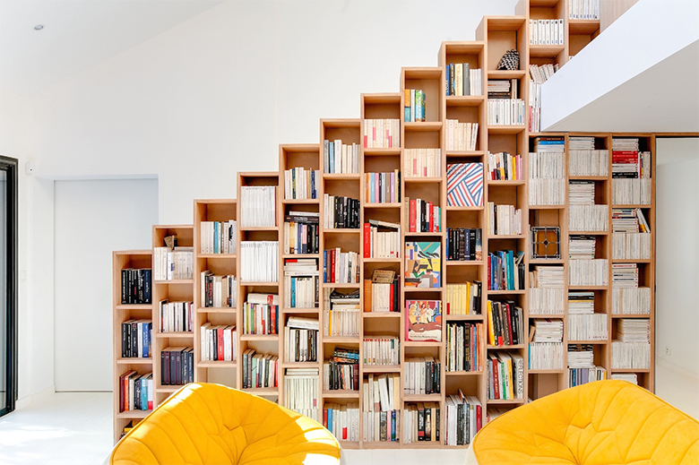 Biblioteca em casa com nichos em painém de escalada