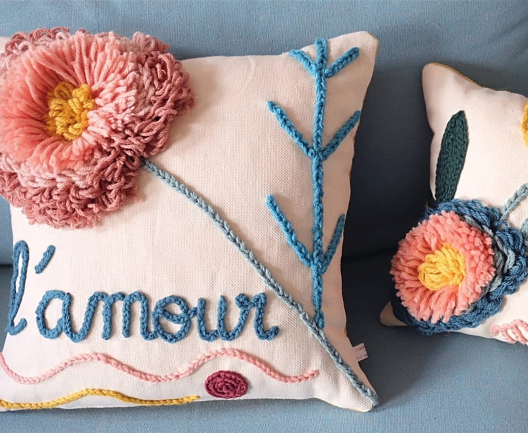 Almofadas em ponto russo com motivos florais em diferentes relevos