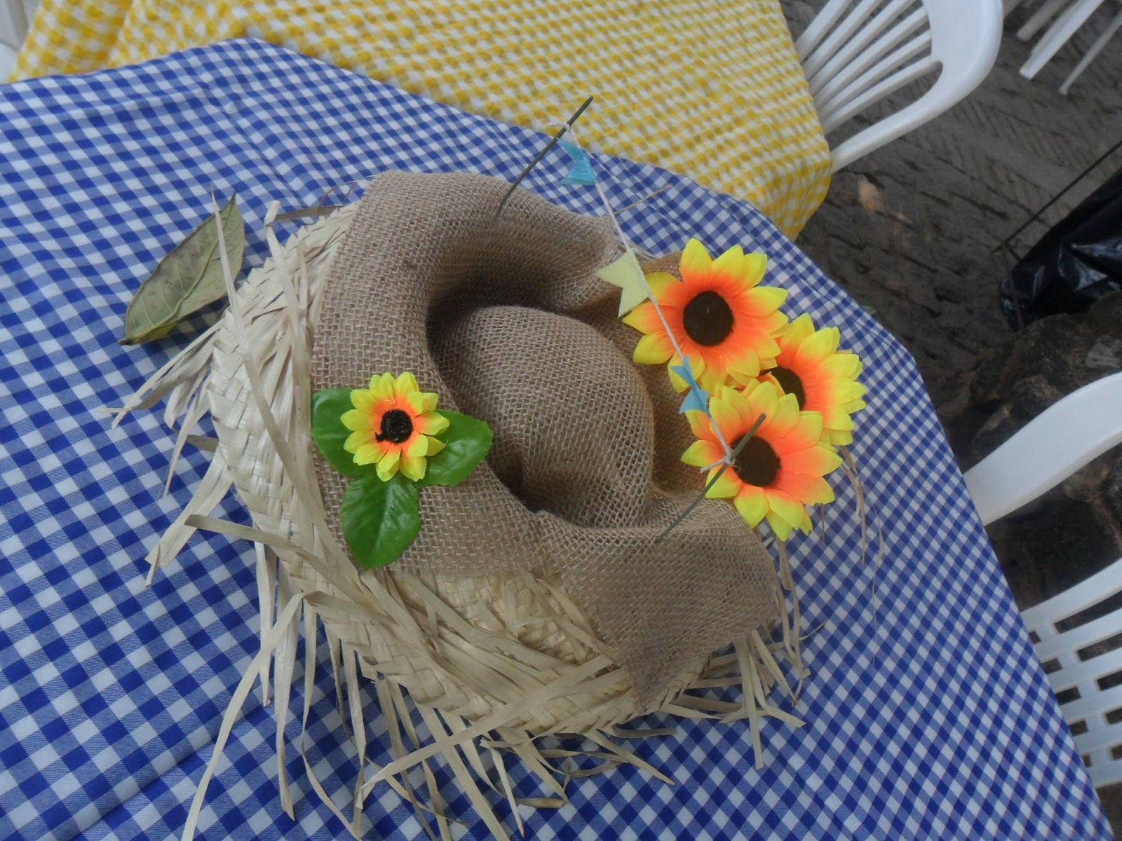 O típico chapéu de palha pode ser decorado com juta e flores e virar um indo enfeite de festa junina de mesa.