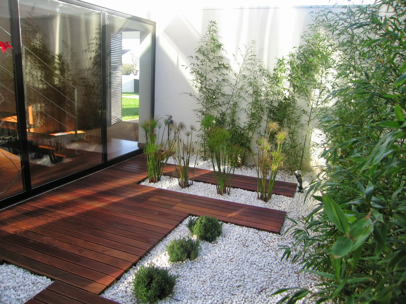 Jardim moderno de inverno com deck e pedras