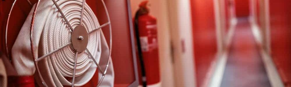 Fire extinguisher and fire hose reel in hotel corridor